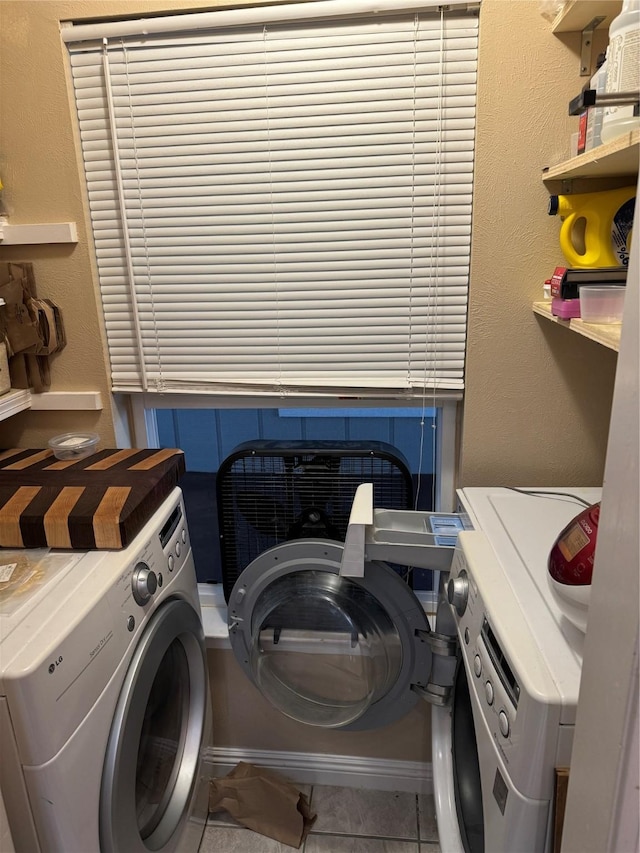 laundry room with a textured wall, laundry area, tile patterned flooring, and washing machine and clothes dryer