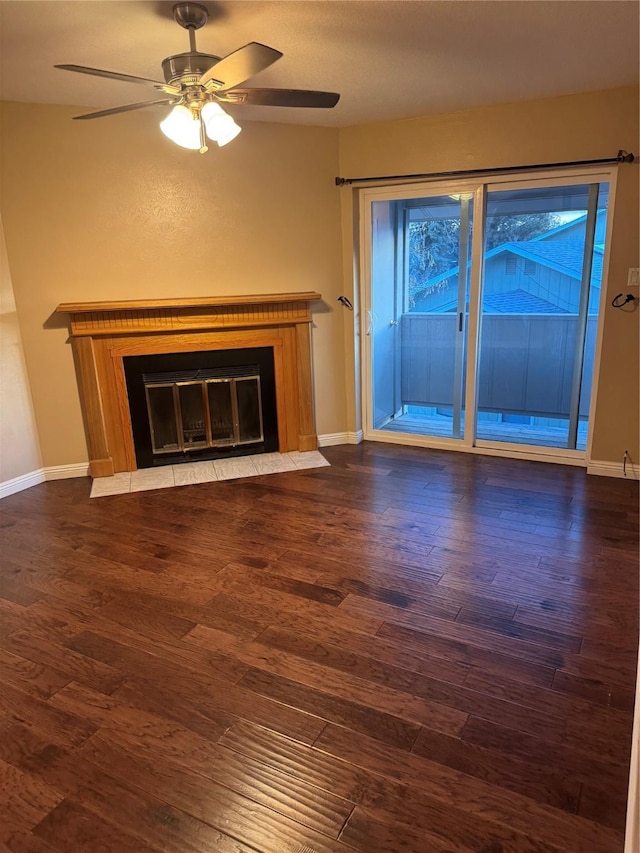 unfurnished living room with dark wood-style flooring, a fireplace with flush hearth, and baseboards