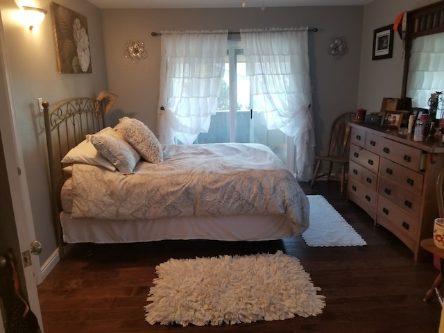 bedroom featuring wood finished floors and baseboards