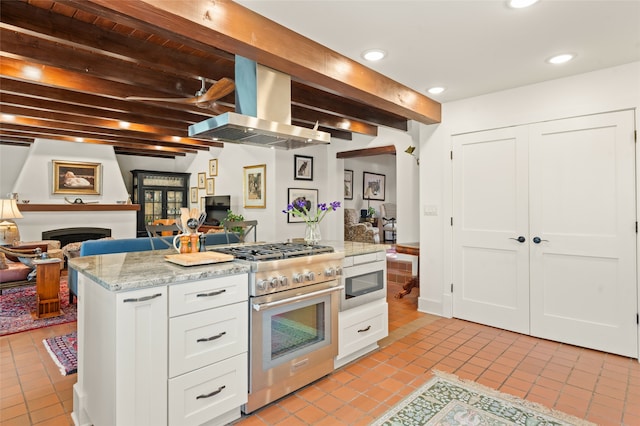 kitchen with white cabinetry, island range hood, light tile patterned floors, beamed ceiling, and stainless steel appliances