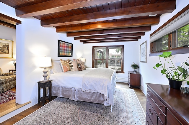 bedroom featuring multiple windows, dark wood-type flooring, wooden ceiling, and beamed ceiling