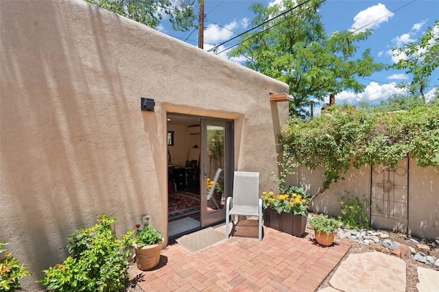 entrance to property with a patio and a wall mounted AC