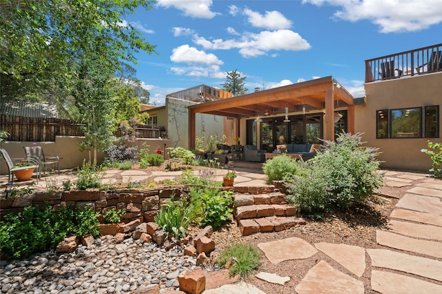 rear view of house with a patio, outdoor lounge area, ceiling fan, and a balcony