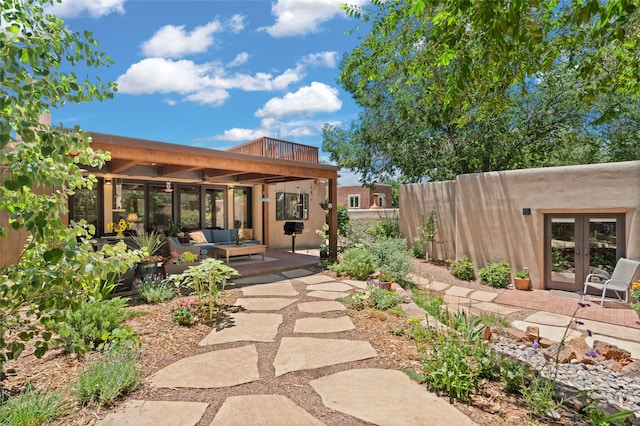 view of yard featuring a patio, an outdoor living space, and french doors