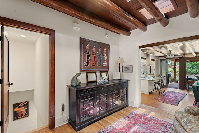 hall with beam ceiling, light hardwood / wood-style flooring, and wooden ceiling