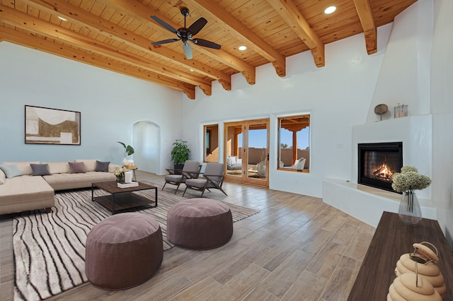 living room featuring beam ceiling, ceiling fan, hardwood / wood-style floors, and wood ceiling