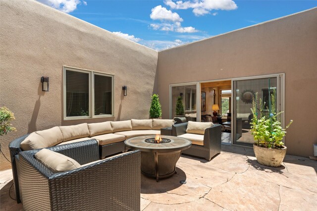 view of patio with an outdoor living space with a fire pit