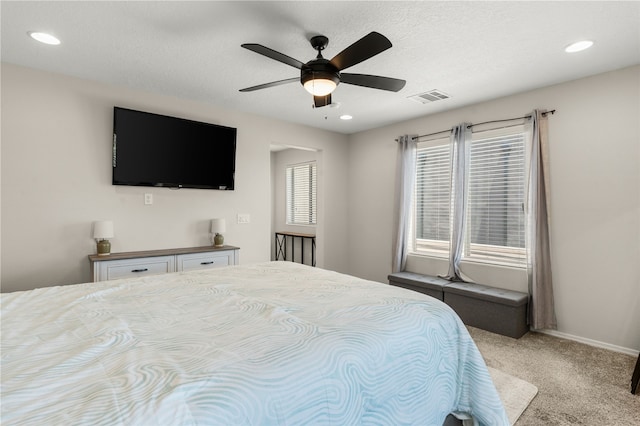 carpeted bedroom featuring ceiling fan and a textured ceiling