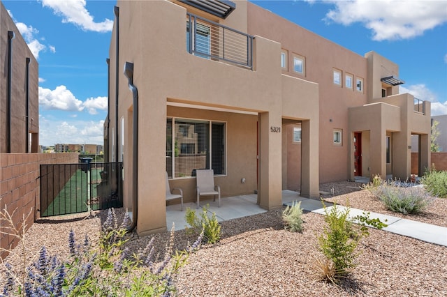 pueblo-style home with a patio area