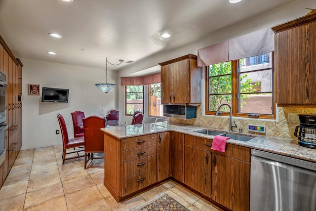 kitchen with kitchen peninsula, tasteful backsplash, pendant lighting, stainless steel dishwasher, and sink