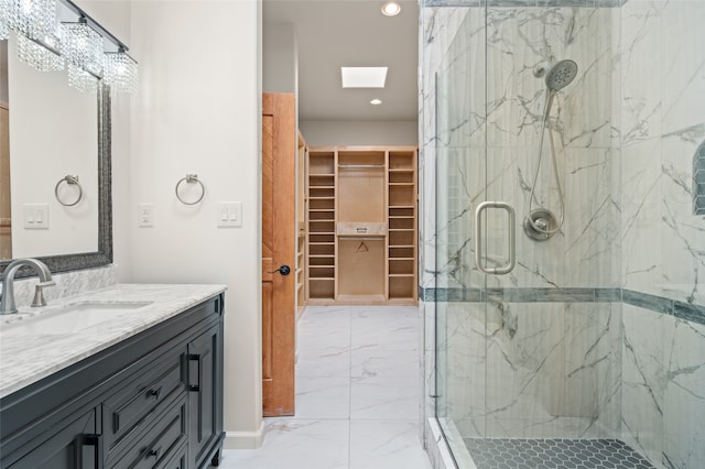 bathroom featuring a shower with shower door, vanity, and a skylight