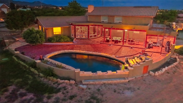 pool at twilight featuring a patio