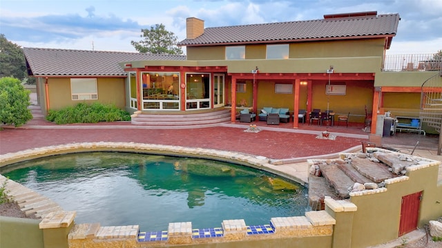 rear view of house featuring a patio and outdoor lounge area