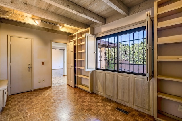 interior space featuring wooden ceiling, visible vents, beamed ceiling, and baseboards