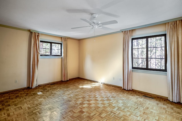 unfurnished room with a ceiling fan, visible vents, crown molding, and baseboards