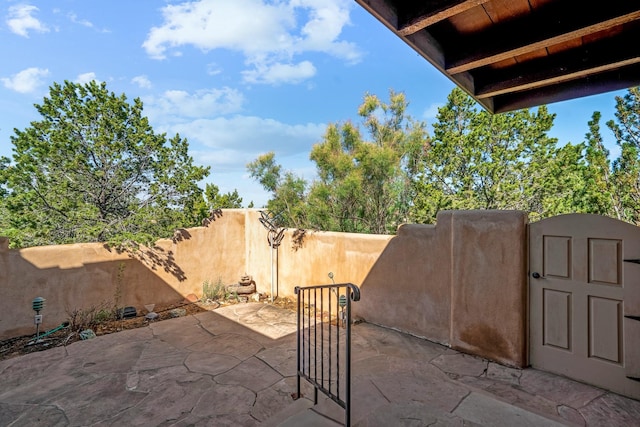 view of patio / terrace featuring a storage shed, an outdoor structure, fence, and a gate