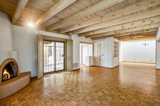 unfurnished living room with a large fireplace, beam ceiling, visible vents, and baseboards