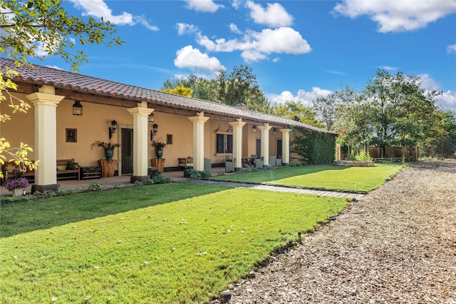 back of house with outdoor lounge area and a yard