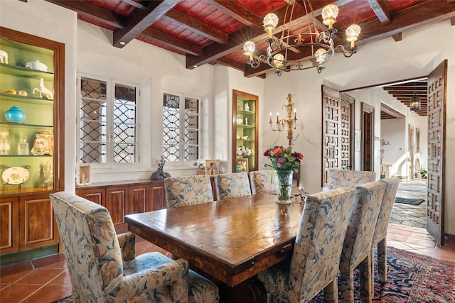 dining space featuring wooden ceiling, dark tile patterned flooring, built in features, a notable chandelier, and beam ceiling