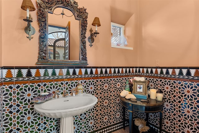 bathroom with sink, a wealth of natural light, and tile walls