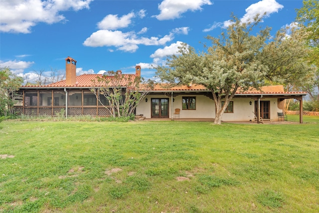 back of property featuring a sunroom and a yard