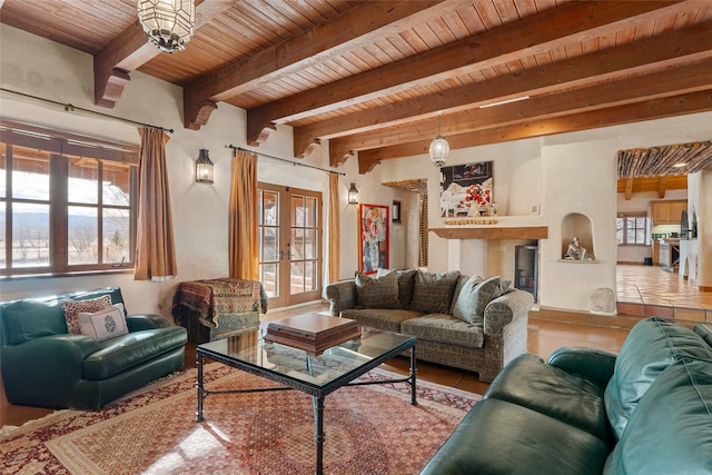 living room featuring beamed ceiling, french doors, tile patterned flooring, and plenty of natural light