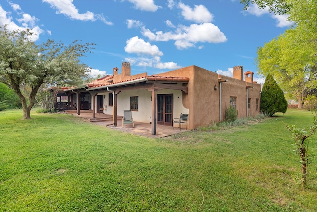 back of property featuring a patio and a lawn