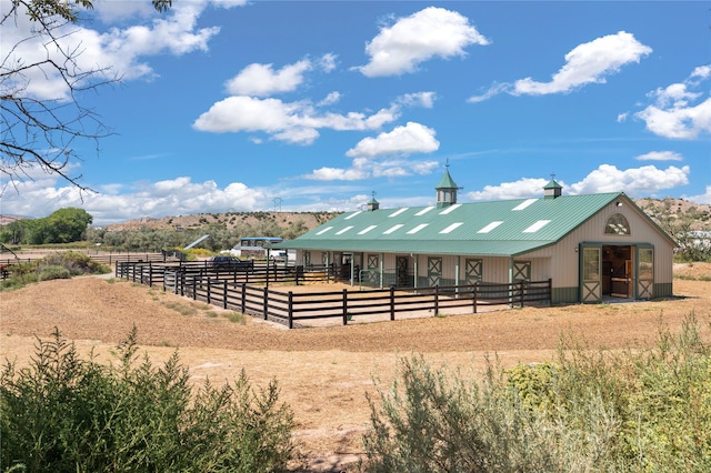 view of horse barn with a rural view