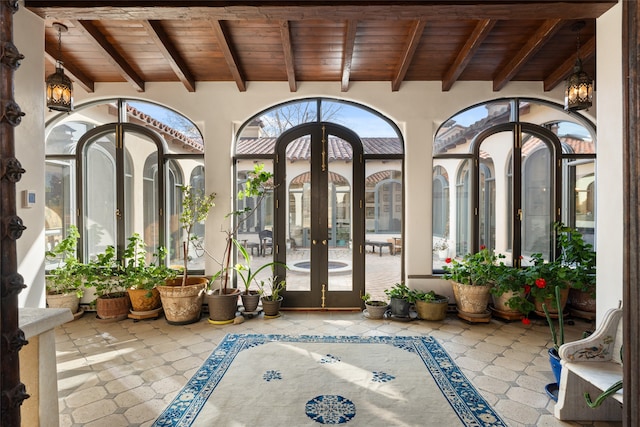 unfurnished sunroom featuring french doors, beamed ceiling, and wood ceiling