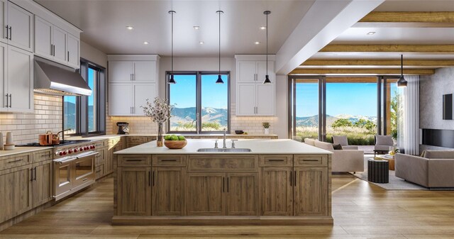 kitchen featuring white cabinetry, tasteful backsplash, beamed ceiling, decorative light fixtures, and sink