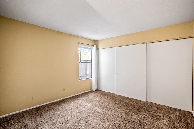 unfurnished bedroom with carpet, a closet, and a textured ceiling