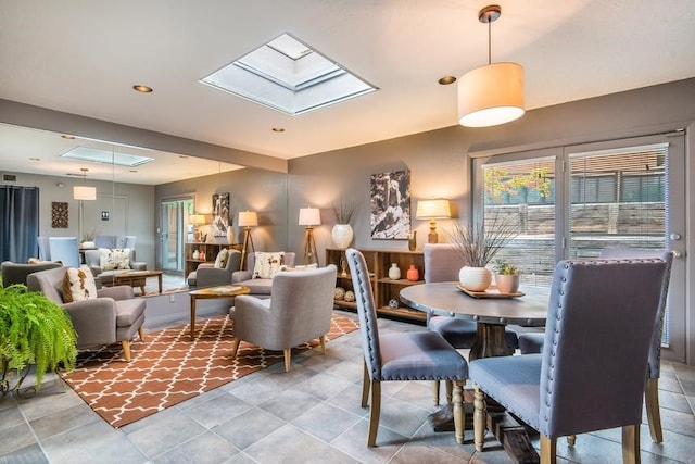 dining area with tile patterned flooring and a skylight