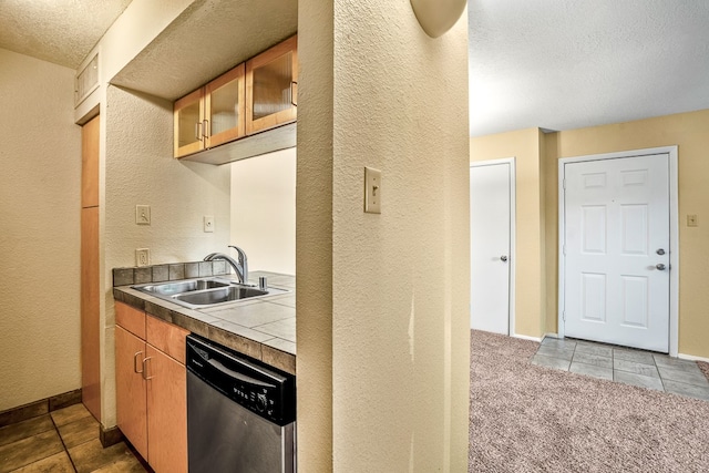 kitchen with tile counters, a textured ceiling, dishwasher, light carpet, and sink