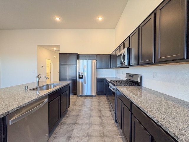 kitchen featuring recessed lighting, light stone countertops, stainless steel appliances, a sink, and light tile patterned flooring