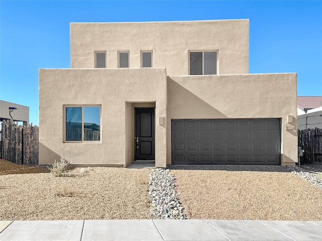 pueblo-style home featuring a garage