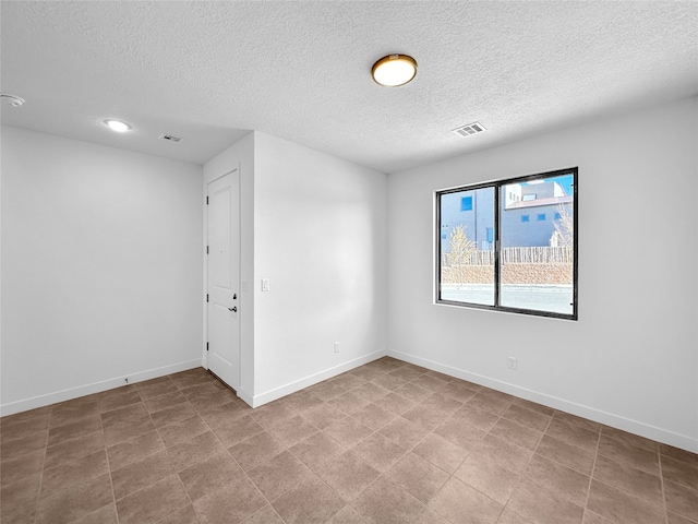 unfurnished room with a textured ceiling