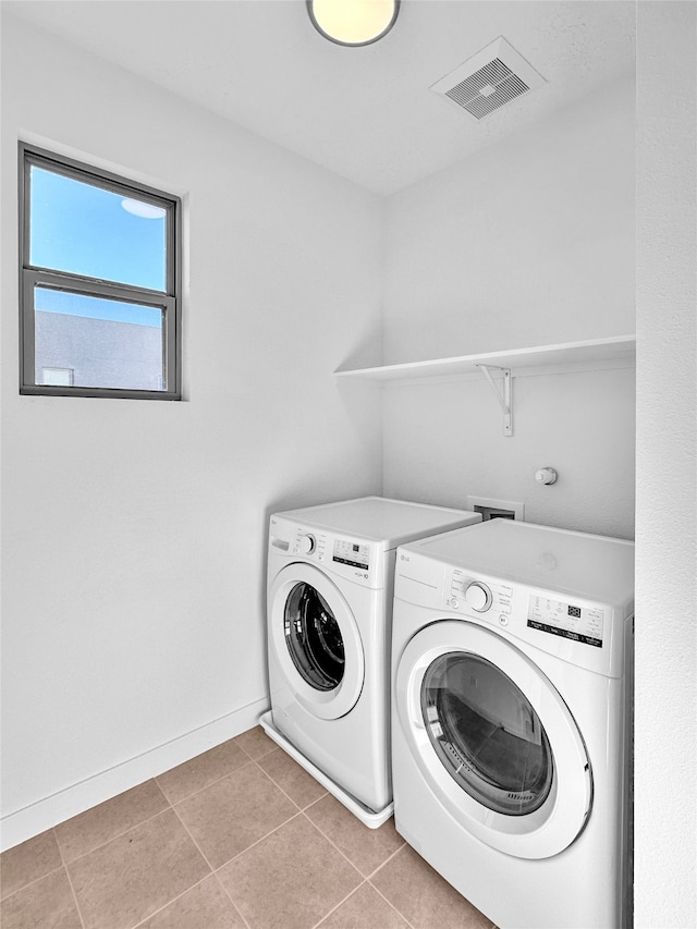 laundry room with washer and dryer and light tile patterned floors