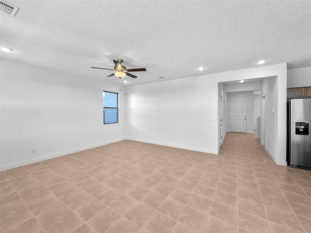 unfurnished room with ceiling fan and a textured ceiling