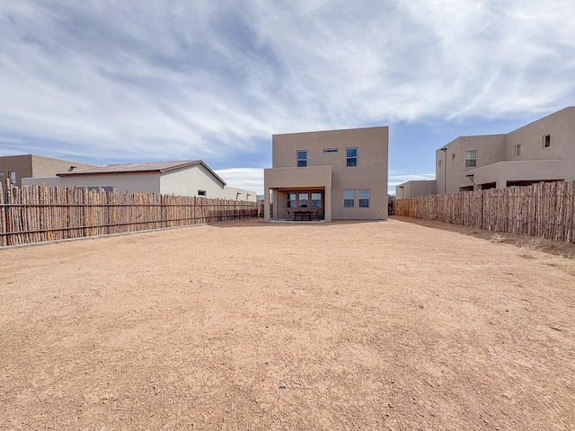 3497 Aster Ln, Santa Fe, NM 87507 - back of property featuring stucco siding, a fenced backyard, and a patio area