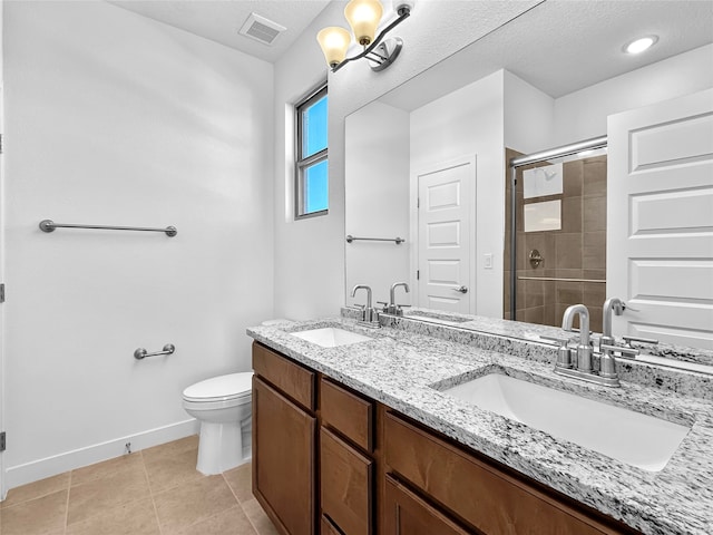 bathroom featuring tile patterned floors, a textured ceiling, an enclosed shower, toilet, and vanity