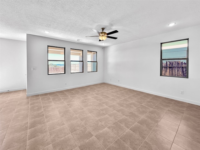 tiled spare room with ceiling fan and a textured ceiling