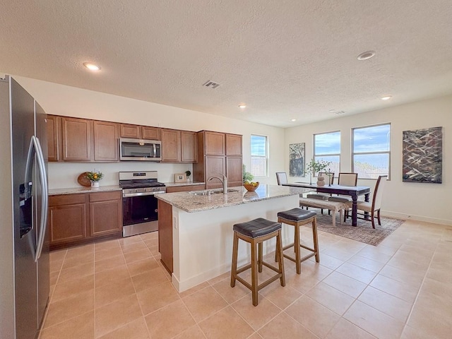 3497 Aster Ln, Santa Fe, NM 87507 - kitchen with a sink, a breakfast bar, appliances with stainless steel finishes, a kitchen island with sink, and visible vents
