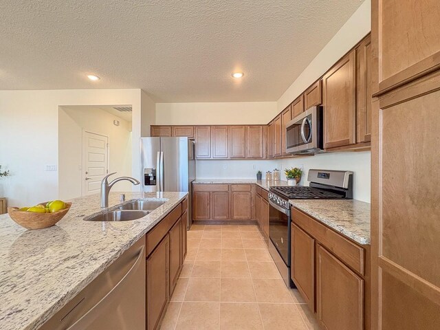 3497 Aster Ln, Santa Fe, NM 87507 - kitchen featuring light tile patterned flooring, light stone countertops, a sink, and appliances with stainless steel finishes
