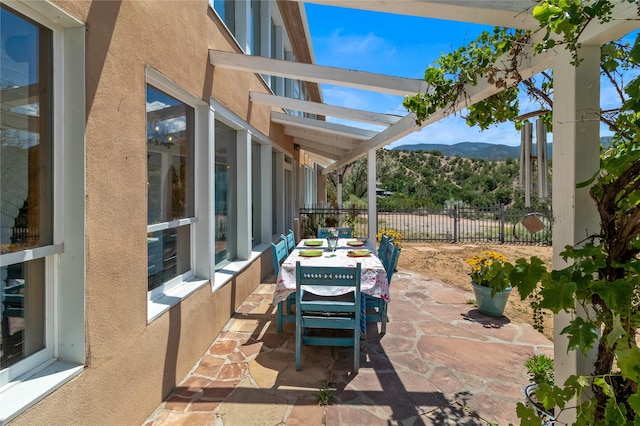 view of patio with fence and a mountain view