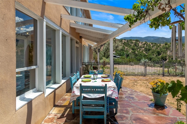 view of patio featuring a mountain view and fence