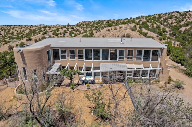 rear view of property with a patio area and stucco siding