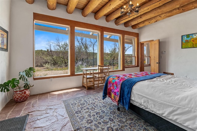 bedroom featuring wood ceiling, multiple windows, beam ceiling, and stone tile flooring