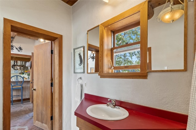 bathroom featuring a textured wall and vanity