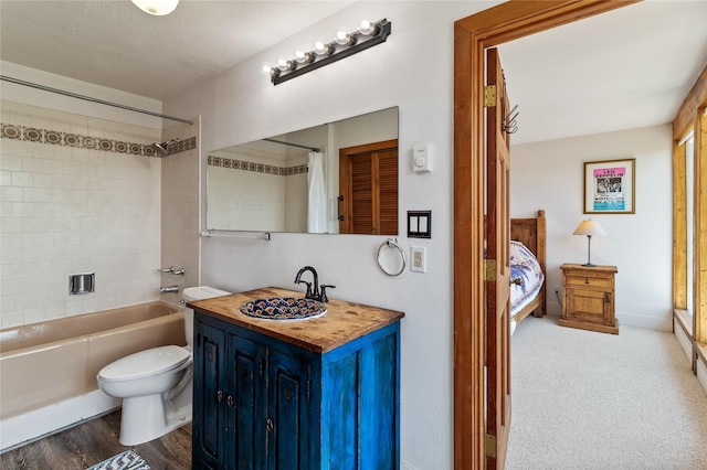 full bathroom with a textured ceiling, vanity, shower / bath combo with shower curtain, and toilet