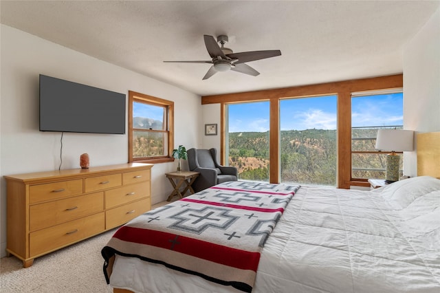 bedroom featuring light carpet and a ceiling fan